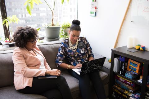 Two girls looking into laptop