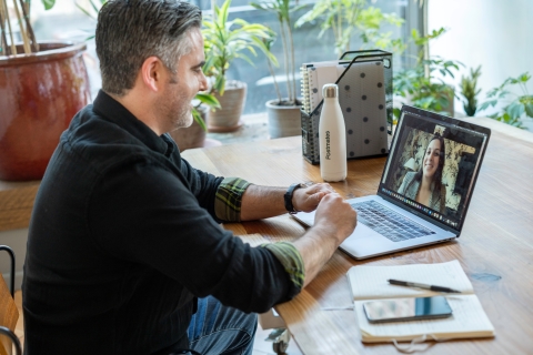 Man looking at coworker on laptop on a video call