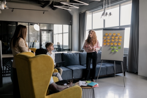 Woman standing next to chart paper with sticky notes